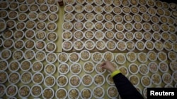 A woman arranges dishes of Burbara, a traditional food served during Saint Barbara's Day, in the village of Aboud, in the Israeli-occupied West Bank, Dec. 16, 2019.