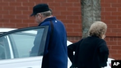 FILE - John Hinckley, left, gets into his mother's car in front of a recreation center during a sanctioned visit with her, in Williamsburg, Virginia, March 19, 2015.