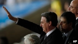 El presidente brasileño Jair Bolsonaro saluda a sus simpatizantes antes de una semifinal de la Copa América entre Brasil y Argentina en Belo Horizonte, Brasil, el martes 2 de julio de 2019. (AP Foto/Nelson Antoine)