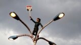 A supporter of deposed Egyptian President Mohamed Morsi holds up his photo while standing at the top of lamp post during a march in Sana&#39;a, Yemen, to show solidarity with his supporters in Egypt.