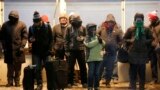 Commuters gather under warming lamps on one of Chicago's famous "El" lines as they experience wind chills expected to reach far below zero, Jan. 6, 2014.