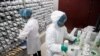 FILE - Medical personnel in protective gear prepare medicine for coronavirus-infected patients, at a pharmacy at Wuhan Tongji Hospital, in Wuhan, China, March 2, 2020. Chinese health officials say a first vaccine should soon be available.