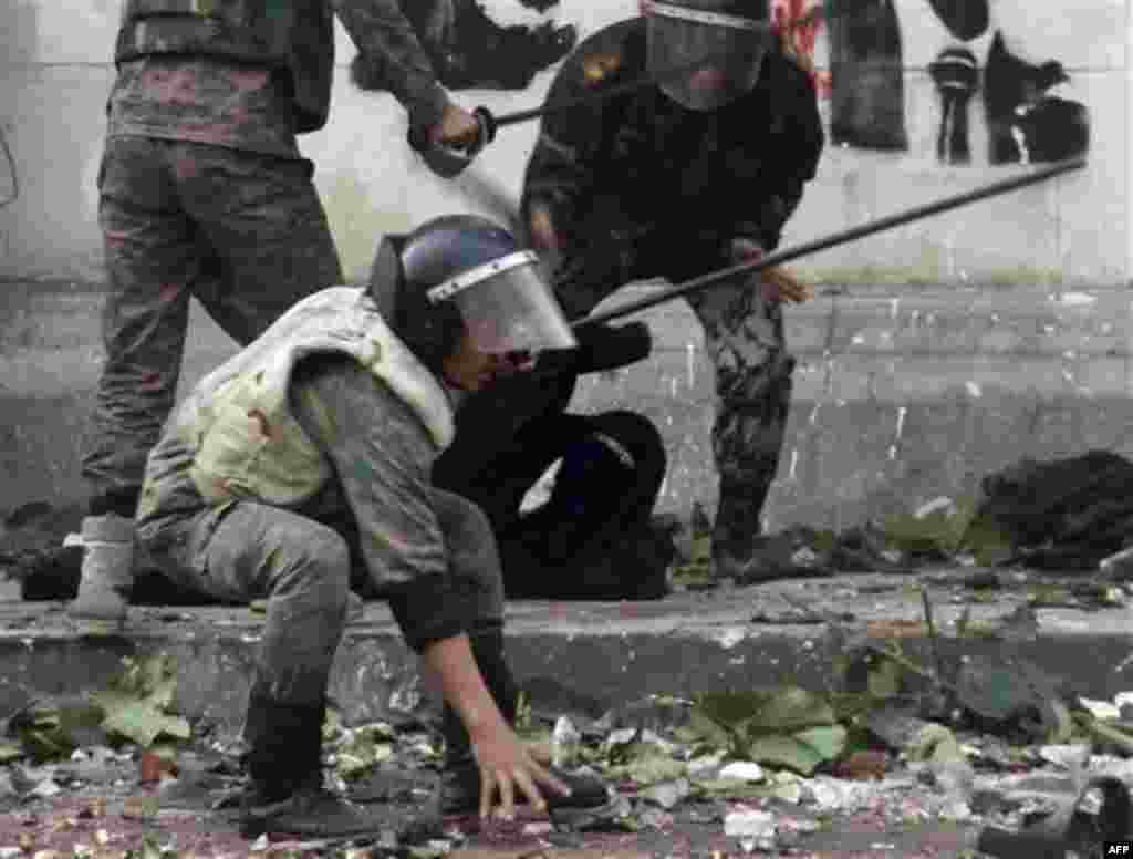 Egyptian army soldiers rear arrest a woman protester wearing the Niqab during clashes near Cairo's downtown Tahrir Square, Egypt, Friday, Dec. 16, 2011. Activists say the clashes began after soldiers severely beat a young man who was part of a sit-in outs