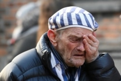 A survivor reacts at the former Nazi German concentration and extermination camp Auschwitz as he attends a wreath-laying ceremony, marking the 75th anniversary of the liberation of the camp, in Oswiecim, Poland, Jan. 27, 2020.