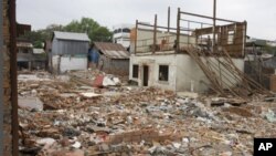 In this photo taken on March 17, 2011, rubble are scattered around houses on the edge of Boeung Kak, Phnom Penh's largest lake. The residents of the area are being evicted from their homes to make way for upscale villas and office buildings. 