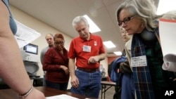 Observers look over test results as a statewide presidential election recount begins Dec. 1, 2016, in Milwaukee. 