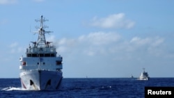 FILE - Chinese coastguard ships give chase to Vietnamese coastguard vessels (not pictured) after they came within 10 nautical miles of the Haiyang Shiyou 981, known in Vietnam as HD-981, oil rig in the South China Sea, July 15, 2014.