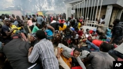 Residents desperate for a planned distribution of food for those suffering under Kenya's coronavirus-related restrictions push through a gate, creating a stampede, in Nairobi, Kenya, April 10, 2020.