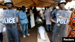 FILE - Security forces stand guard near the bodies of protesters, killed during a rally, in Conakry, Guinea, Oct.2, 2009.