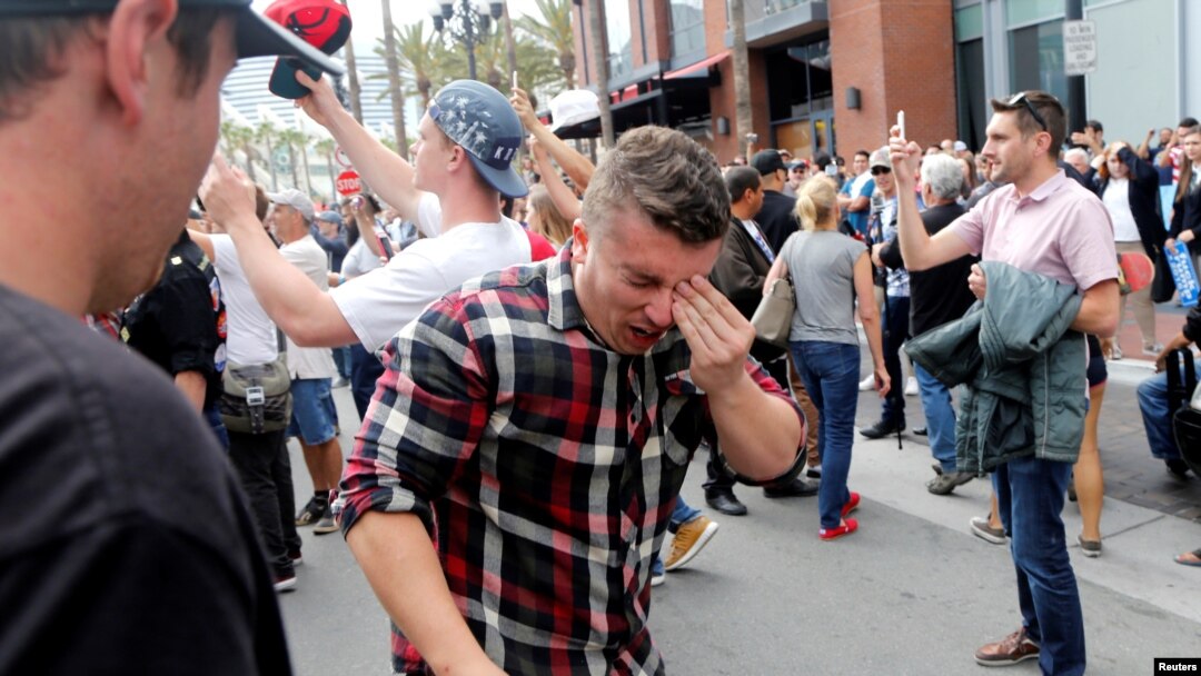Seorang pria mengusap matanya yang terkena semprotan merica dalam aksi unjuk rasa dalam kampanye Donald Trump di San Diego, California (27/5).