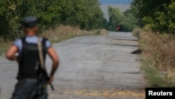 A red flag attached to a pro-Russian separatist tank is seen near a checkpoint of the Ukrainian national guard near the town of Slovyanoserbsk, Luhansk region, Sept.10, 2014.