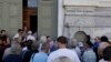 The first customers, most of them pensioners, stand in a queue to enter a branch at National Bank of Greece headquarters in Athens, July 20, 2015.