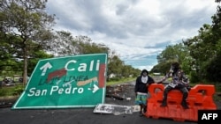 Manifestantes bloquean la carretera Panamericana, junto a un cartel que dice “la primera línea”, para protestar contra el gobierno del presidente Iván Duque, entre Buga y Cali, en el departamento del Valle del Cauca, Colombia, el 26 de mayo de 2021.