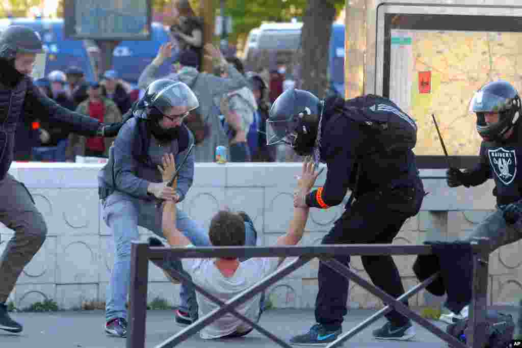 Riot police detain a man during the traditional May Day march in Paris, France, May 1, 2016. The traditional May Day rallies are taking on greater weight this year in France as parliament is debating a bill that would allow longer working hours and let co