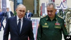 Президент Росії Володимир Путін (ліворуч) і міністр оборони Росії Сергій Шойгу прибувають на зустріч із вищим військовим керівництвом у Москві, Росія, 19 грудня 2023 року. (AP)