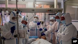 A patient infected with COVID-19 is treated in one of the intensive care units (ICU) at the Severo Ochoa hospital in Leganes, outskirts of Madrid, Spain, Friday, Oct. 9, 2020. At the peak of the first wave, ICU wards were given over to haste, desperation 