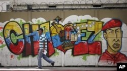 A man walks past a mural of Venezuela's President Hugo Chavez in Caracas, Jan. 2, 2013.