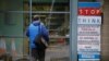 A man walks toward a coronavirus warning sign outside a medical center in Manchester, Britain.