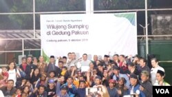 Tujuh puluh satu warga Jawa Barat disambut Gubernur Jabar Ridwan Kamil di Bandung, usai dipulangkan usai kerusuhan di Wamena, Papua. (VOA/Rio Tuasikal)