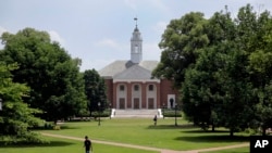 FILE - People walk on Johns Hopkins University's Homewood campus in Baltimore, Md.