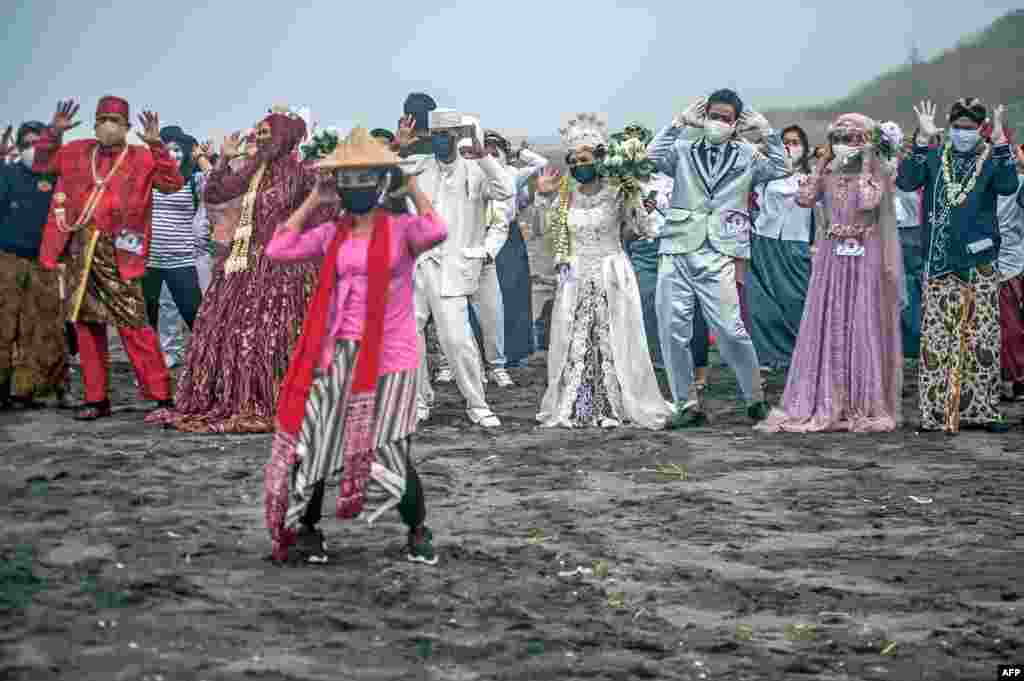 Brides and grooms dance during a mass wedding of 75 couples at a field in Bantul, Yogyakarta, Indonesia.