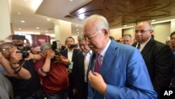 Former Malaysian Prime Minister Najib Razak, center, walks out from the courtroom at the court house in Kuala Lumpur, Malaysia, for his corruption trial, Dec. 3, 2019.