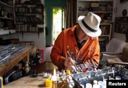 Ben Wilson, paints a tile piece in his home studio in Muswell Hill, London, Britain, August 21, 2023. (REUTERS/Anna Gordon)