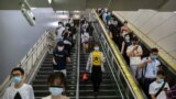 Commuters wearing face masks to protect against the spread of the new coronavirus walk through a subway station in Beijing, July 9, 2020. 