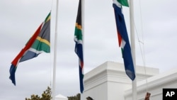 Afisa wa polisi akipandisha bendera nje ya bunge la Afrika kusini mjini Cape Town, Afrika kusini, Nov. 25, 2020. 