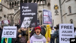 Demonstrators hold banners outside the Royal Courts of Justice in London, Feb. 20, 2024. Lawyers for WikiLeaks founder Julian Assange made his final appeal against his impending extradition to the United States at the court.