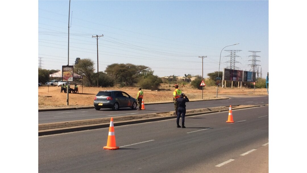Soldiers and police monitor a roadblock in the capital, Gaborone, which is under a two-week lockdown, July 31, 2020. (Mqondisi Dube/VOA)