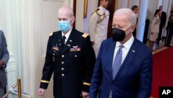 El presidente Joe Biden llega con el capitán Larry Taylor, un piloto del ejército de la guerra de Vietnam, a la ceremonia de entrega de la Medalla de Honor el 5 septiembre de 2023, en el Salón Este de la Casa Blanca en Washington.