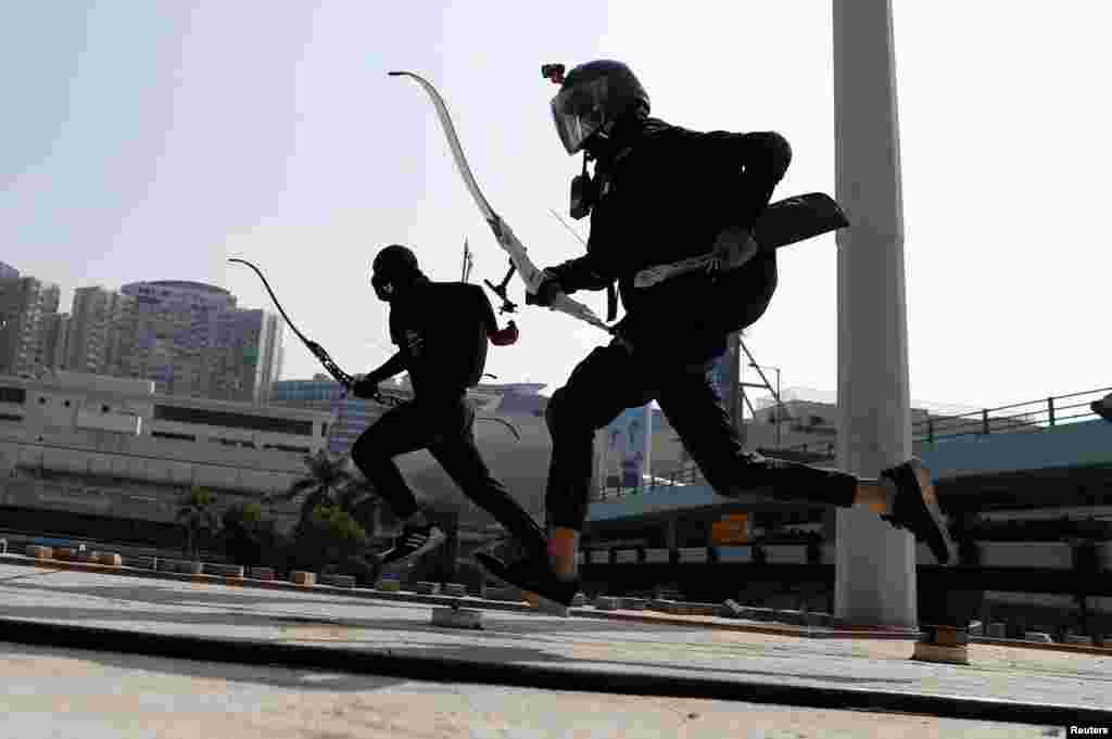 Protesters race with bows as they practice running away from riot police in Hong Kong, China.