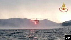 In this image released by the Italian firefighters a helicopter search for missing after a tourist boat capsized in a storm on Italy's Lago Maggiore in the northern Lombardy region, May 28, 2023.