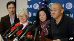 Family members watch as Kenneth Bae, right, freed during a top-secret mission, talks to reporters after he arrived at Joint Base Lewis-McChord, Washington, Nov. 8, 2014.