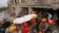 Bangladeshi rescue workers carry the body of a dead garment worker after it was retrieved from a building that collapsed on Wednesday in Savar, near Dhaka, Bangladesh, April 28, 2013.