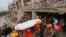 Bangladeshi rescue workers carry the body of a dead garment worker after it was retrieved from a building that collapsed on Wednesday in Savar, near Dhaka, Bangladesh, April 28, 2013.