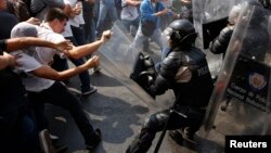 Manifestantes antigubernamentales chocan con la policía durante una protesta en Caracas.