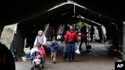 Kelompok migran melintasi garis perbatasan antara Serbia dan Kroasia, dekat desa Berkasovo, sekitar 100 kilometer dari Belgrad, Serbia (17/10). Kroasia mengalihkan migran ke Slovenia setelah Hungaria menutup perbatasannya dengan Kroasia.