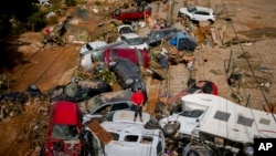 A man stands among cars destroyed in recent flooding in Valencia, Spain, Oct. 31, 2024.