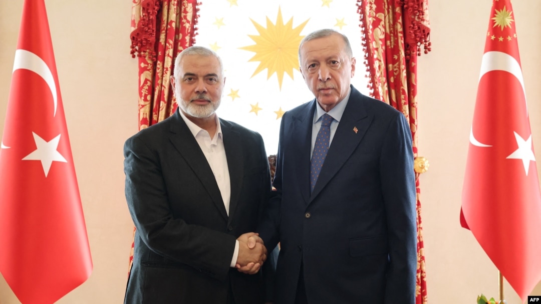 This handout photograph taken and released by Turkish Presidency Press Office on April 20, 2024, shows Turkish President Recep Tayyip Erdogan, right, shaking hands with Ismail Haniyeh, the political leader of Hamas, at the Dolmabahce Presidential working office in Istanbul.