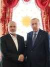 This handout photograph taken and released by Turkish Presidency Press Office on April 20, 2024, shows Turkish President Recep Tayyip Erdogan, right, shaking hands with Ismail Haniyeh, the political leader of Hamas, at the Dolmabahce Presidential working office in Istanbul.