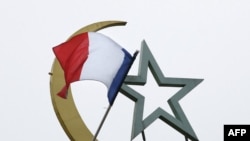 FILE - A French national flag flutter on top of the Grand Mosque of Paris, in Paris, France, Nov. 27, 2015.