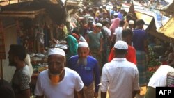 Rohingya refugees walk in market area inside a refugee camp in Ukhia on April 6, 2021 during the second day of weeklong government-imposed lockdown amid an increase of COVID-19 coronavirus cases. (Photo by Miraj KATEB / AFP)