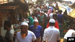 Rohingya refugees walk in market area inside a refugee camp in Ukhia on April 6, 2021 during the second day of weeklong government-imposed lockdown amid an increase of COVID-19 coronavirus cases. (Photo by Miraj KATEB / AFP)