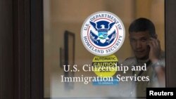 Un guardia de seguridad observa a través de la puerta cerrada de una oficina de inmigración en Nueva Jersey.