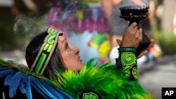 A member of the Grupo Coatlicue begins a traditional Aztec dance, an agricultural prayer ceremony in motion, during an Indigenous Peoples' Day event, Monday, Oct. 14, 2024, in Phoenix, Arizona. (AP Photo/Ross D. Franklin)