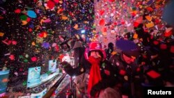 FILE - Revelers toss confetti over Times Square during New Year's Eve celebrations in New York January 1, 2015. 