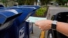 FILE - A person drops applications for mail-in ballots into a mailbox in Omaha, Nebraska, Aug. 18, 2020.