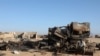 A man sits beside the wreckage of burnt military supply vehicles used by suspected Islamic State fighters in the Cal Miskaad mountain range in Bari, east of the Gulf of Aden in the city of Bosaso, Puntland region, Somalia, Jan. 25, 2025.